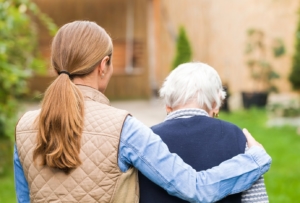 Young carer walking with the elderly woman in the park